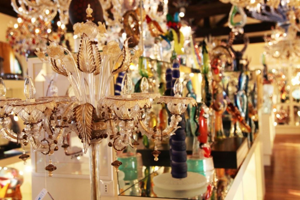 조명이 밝은 방에는 화려한 유리 샹들리에와 정교한 디자인과 다양한 색상의 조각품이 전시되어 있습니다.