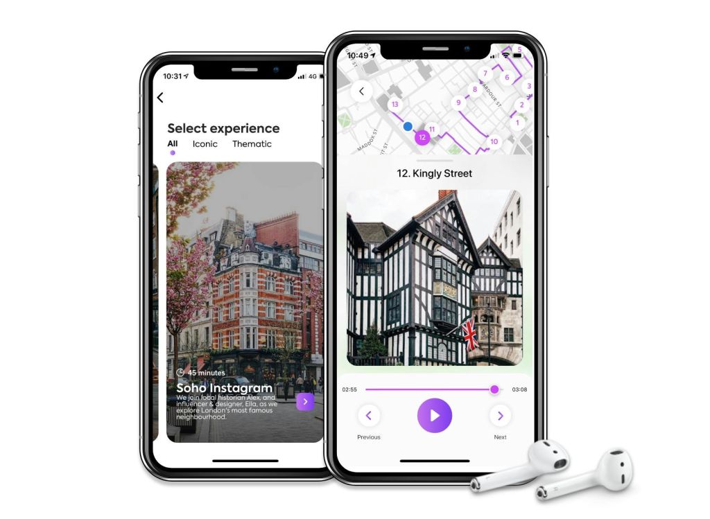 두 대의 스마트폰에는 도시 거리의 지도와 이미지가 담긴 여행 앱이 표시되며, 그 옆에 흰색 이어폰이 놓여 있습니다.