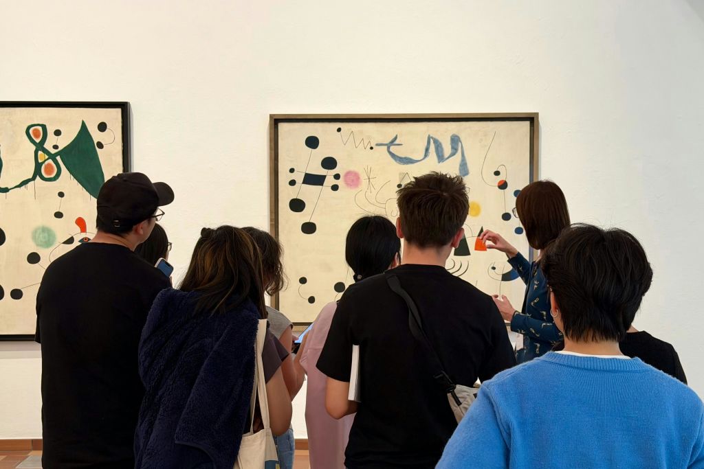 갤러리에서 추상적인 그림을 보고 있는 한 무리의 사람들.