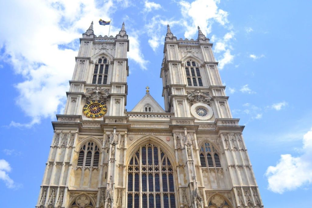 높은 쌍둥이 타워와 푸른 하늘 아래 디테일한 건축물이 있는 커다란 고딕 양식의 대성당 외관.