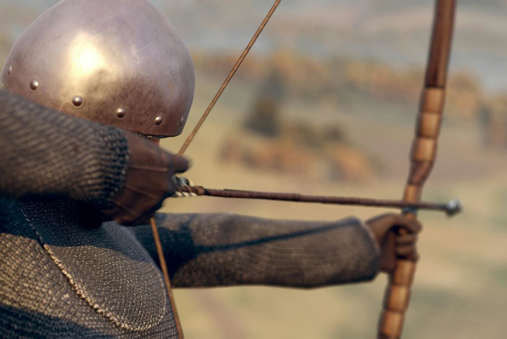 쇠사슬과 투구를 쓴 중세 궁수가 활을 쏘며 먼 곳을 겨냥하고 있습니다.