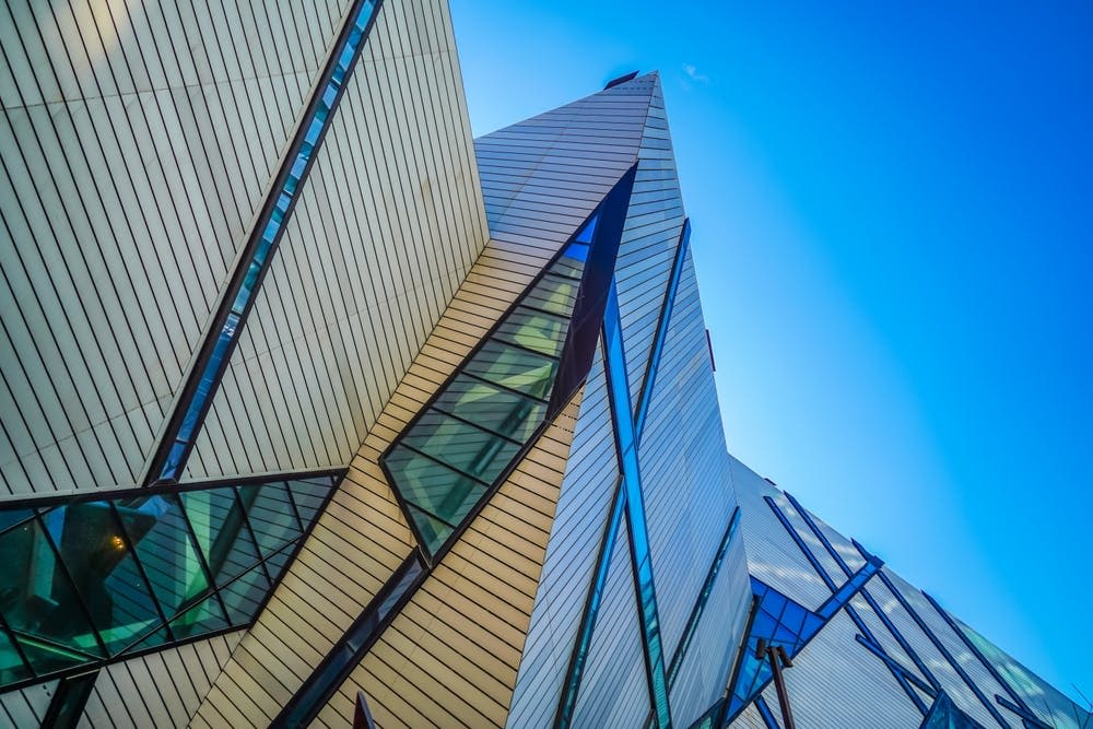 맑고 푸른 하늘을 배경으로 날카롭고 각진 특징과 유리창이 있는 현대적인 건물입니다.