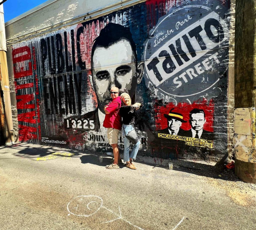 악명 높은 갱스터 알 카포네와 존 딜린저와 함께 시카고 범죄 투어에서 포즈를 취합니다.