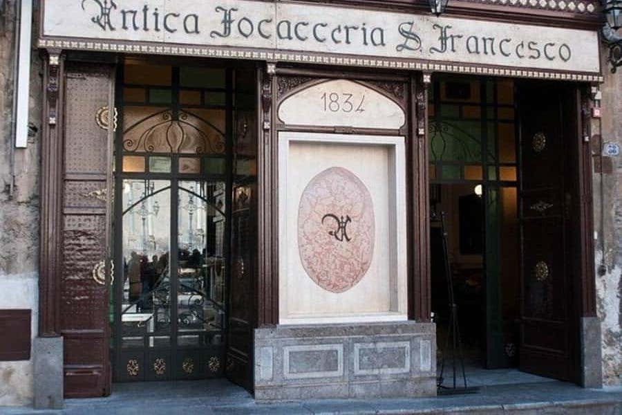 화려한 장식과 유리 문, 커다란 엠블럼 위에 새겨진 "1834" 가 있는 "Antica Focacceria S. Francesco" 입구.