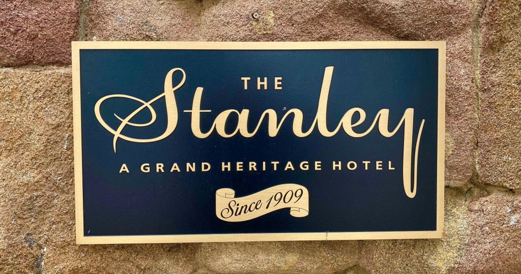 돌 배경에 'The Stanley, A Grand Heritage Hotel, Since 1909' 라고 적힌 간판.