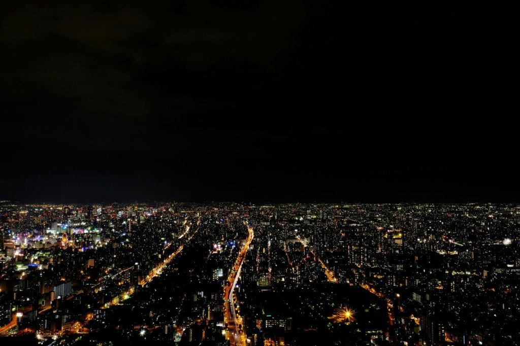 어두운 하늘 아래 조명이 켜진 거리와 건물을 보며 밤에는 도시 풍경을 조망할 수 있습니다.