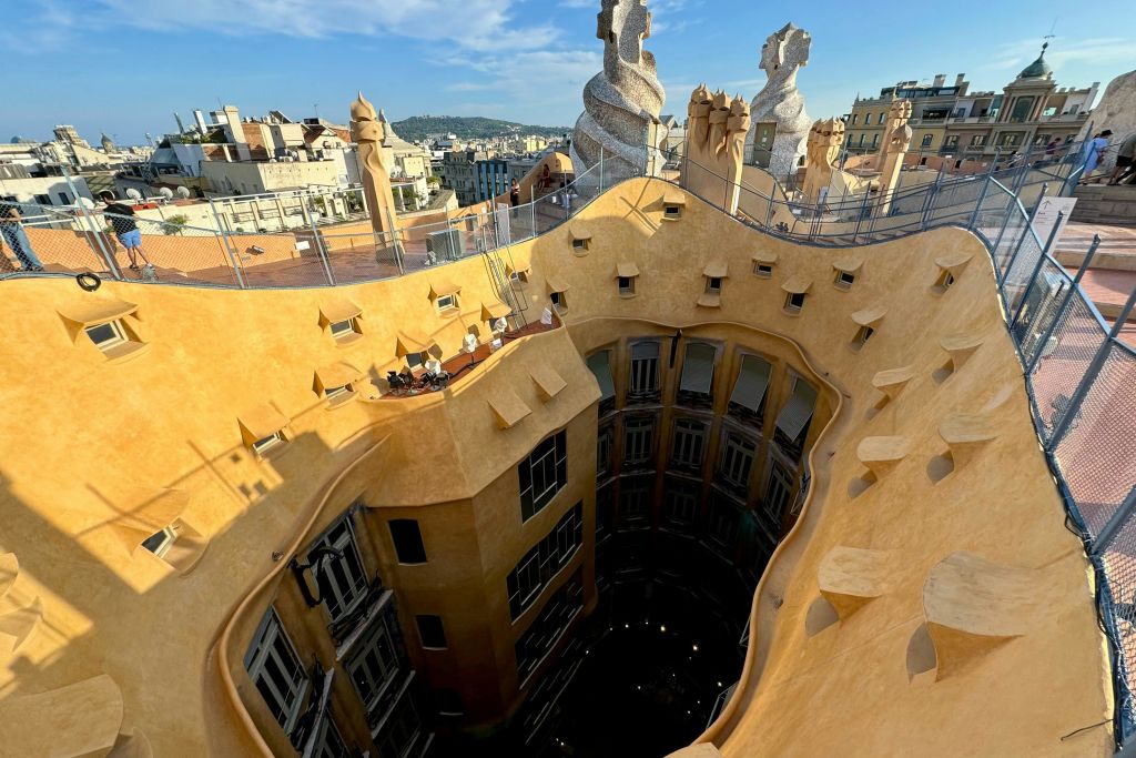 옥상에서 라 페드레라의 중앙 안뜰을 내려다보며 건물의 독특한 유기적 형태를 강조합니다.