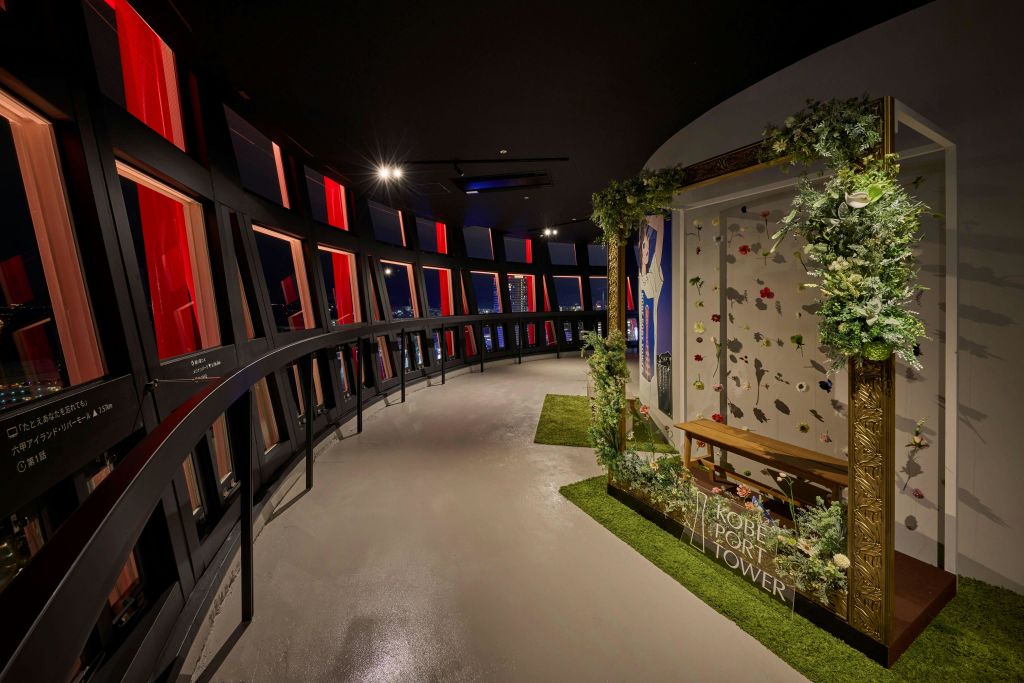 조명이 켜진 타워, 현대적인 흰색 구조물, 물에 비친 높은 건물이 있는 바닷가의 야경.