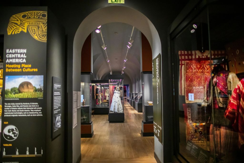 박물관의 복도는 전시실로 이어지며, 전시실 중앙의 마네킹에 흰색 드레스가 전시되어 있습니다.