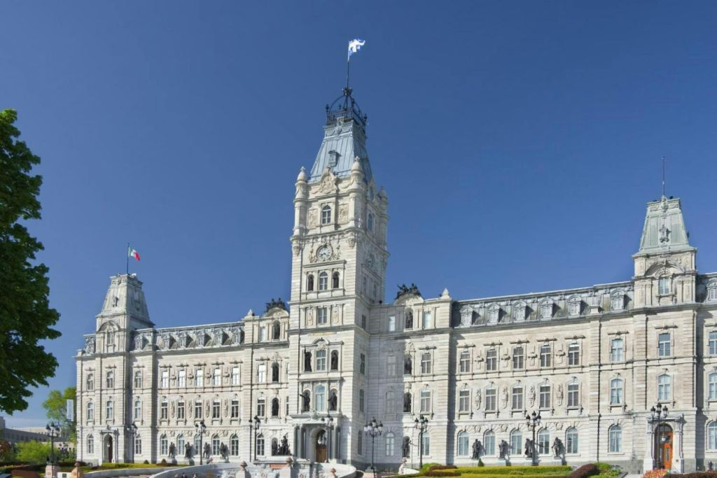 중앙 탑이 깃발을 휘날리고 있는 크고 화려한 건물로, 맑고 푸른 하늘을 배경으로 하고 있습니다.